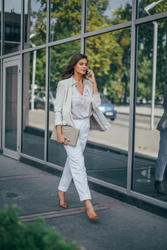 Series of a business woman in the city. Beautiful brunette sitting in coffee shop and working on com