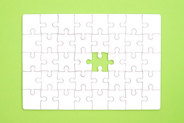 White jigsaw puzzle on green background