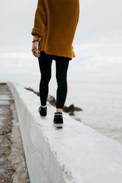 Solitary woman walking on apier