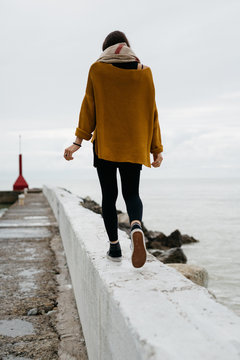 Solitary woman walking on apier