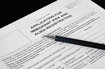 Obraz premium Paper Form immigration visa lies on the black surface