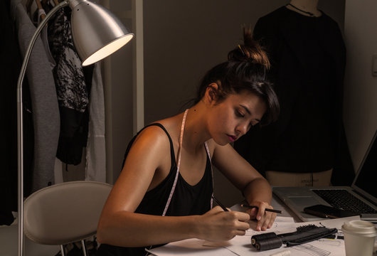 Young Fashion Designer Working in her studio until late hours.