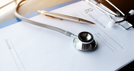 Stethoscope and record information paper folder with pen on Laptop, smart phone at medicine doctor work, on blur patient in hostpital, Concept of Health Care and Medical. Selective focus.