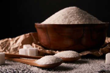 Bowl and spoon full of white sugar and sugar cubes
