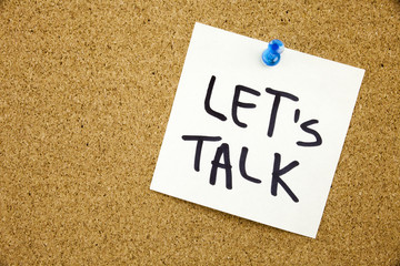 A yellow sticky note writing, caption, inscription Phrase LET'S TALK in black ext on a sticky note...