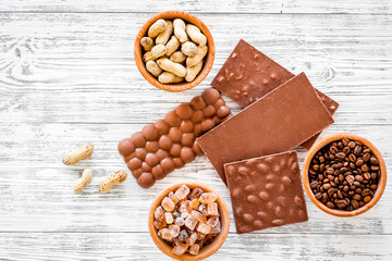 Chocolate bars of different varietes on grey wooden background top view