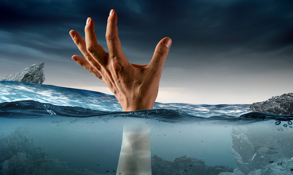 Hand of person drowning in water