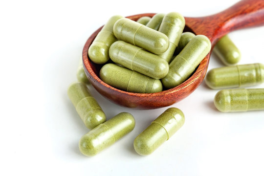Moringa capsules on white background
