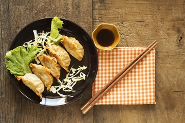 Gyoza / Gyoza in the black plate on the old wooden floor.