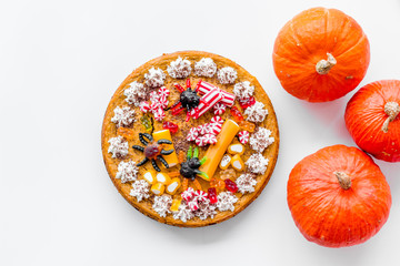 Pie for halloween with gummy spiders near pumpkins on white background top view copyspace