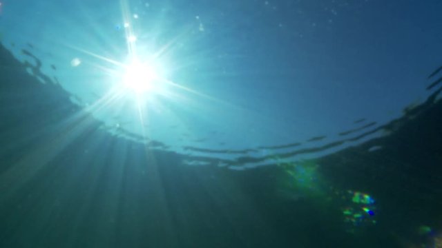 Sun shining through water surface 