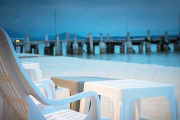 Fototapeta na wymiar chair on beach of relaxing lake at sunset
