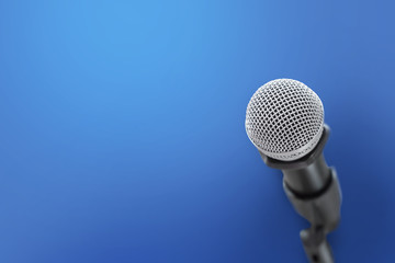 Close up of microphone for voice speaker on blue background.