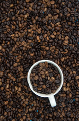 top view of cup of coffee with coffee seed background
