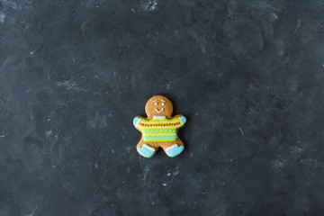 Ginger men with colored glaze on a gray background .. Gingerbread. Christmas cookies. Ginger man in a colored sweater