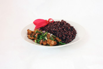 Fried chicken Spicy Salad with Rice berry in the white dish, Food decoration with spring onion and red canna flower.
