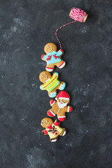 Ginger men with colored glaze on a gray background .. Gingerbread. Christmas cookies. Ginger man in a colored sweater. Gingerbread Santa