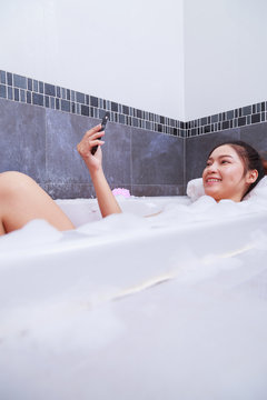 woman making selfie photo in bathtub in bathroom