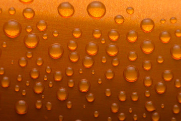 close up drops of water on orange aluminium can