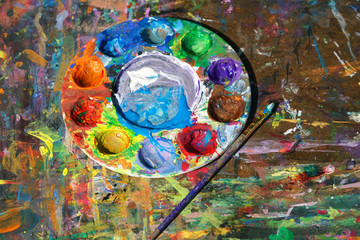 Fototapeta premium Round watercolor palette and paint brush on the board with color