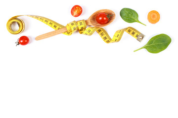 Wooden spoon wrapped in tape measure and fresh ripe vegetables, concept of slimming