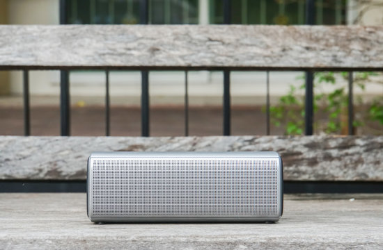 creative design portable wireless bluetooth speaker for music listening on wooden bench