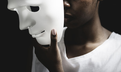 Black woman holding white mask