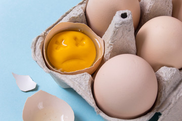 One chicken egg is broken and the yolk is sad or dead. Rotten egg