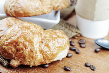 Croissants and coffee on wooden.