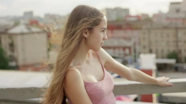 emotions, lifestyle, people, teens, 4k and sunset concept - Young blonde girl is wondering down the streets. Cute smile. Summer, sun is shining. sunset. female portrait. . Slow motion