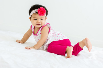 Obraz na płótnie Canvas Portrait of adorable baby sliding on a sloped floor with head band