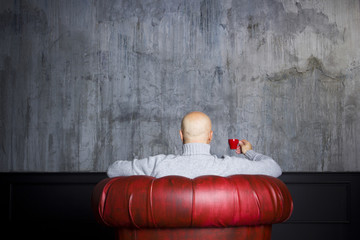 Bald man in the red armchair