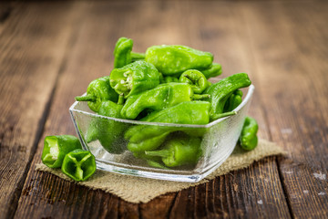 Wooden table with Raw Pimientos, selective focus