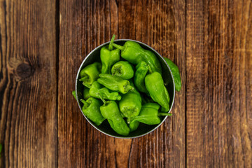 Wooden table with Raw Pimientos, selective focus