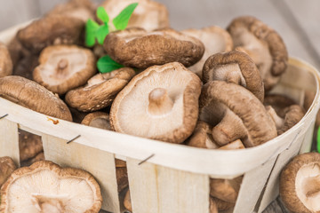Portion of Raw Shiitake mushrooms on wooden background, selective focus