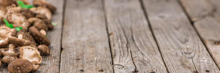 Portion of Raw Shiitake mushrooms on wooden background, selective focus