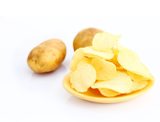 Potato chips on wooden plate on white