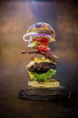 Hamburger with realistic flying ingredients. Tasty smoked grilled and glazed beef burger with...