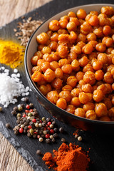 Spicy Roasted chickpeas in a bowl and ingredients close-up. vertical
