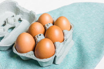 Fresh chicken eggs against white and blue background
