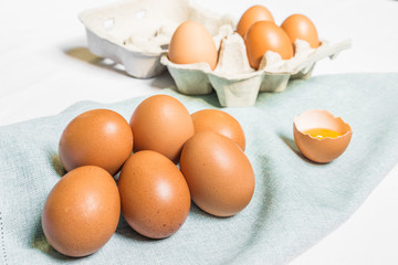 Fresh chicken eggs against white and blue background