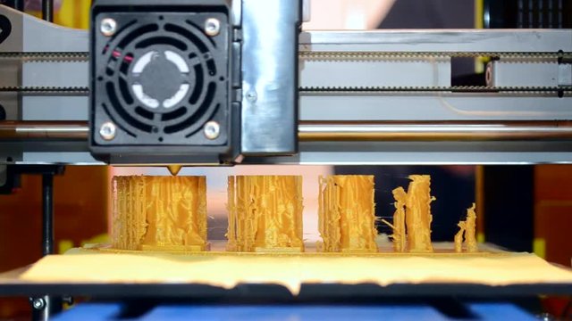 3d printer building yellow object liquid molten plastic close-up. The concept of modern additive technology. The 4ht industrial revolution.