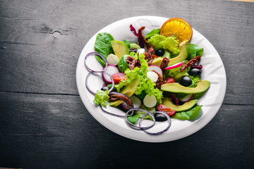 Avocado Salad with grilled meat and greens. Italian cuisine. Top view. On Wooden background.