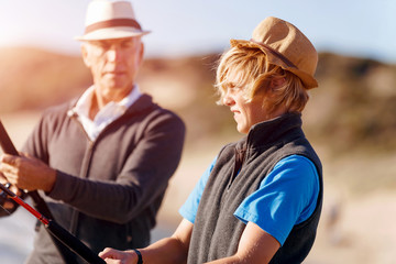 Fototapeta premium Senior man fishing with his grandson
