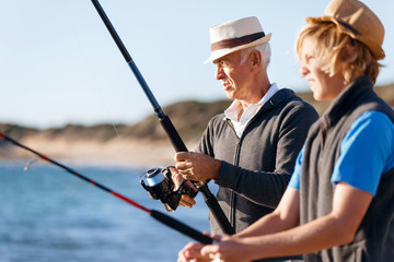Obraz premium Senior man fishing with his grandson