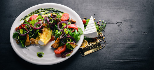 Brie cheese with grilled vegetables. Top view. Free space for text. On a wooden background.