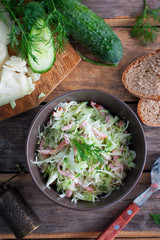 Salad with cabbage, cucumber and ham, top view, selective focus