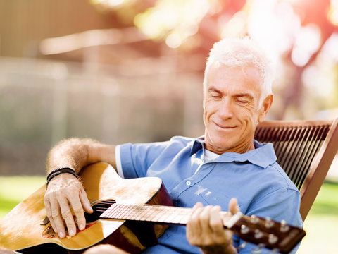 Senior Man Plying Guitar Outdoors