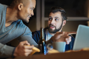 Delighted man pointing at computer