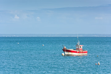 Naklejka na ściany i meble Bright blue sea and a fisherman boat